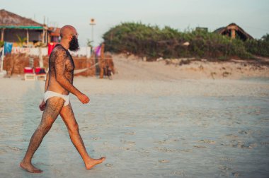 Hindistan, Goa-15 Kasım 2012: Kıllı vücut yürüyüşler Hint sahilde günbatımı sırasında bilinmeyen beyaz erkek. Kıllı vücut. Bir sakallı bir adam