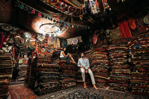 Guy and girl in the store. Couple in love in Turkey. Man and woman in the Eastern country. Gift shop. A couple in love travels. Persian shop. Tourists in store. Oriental carpet. Istanbul. Emirates