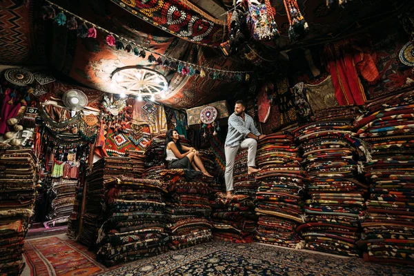 Guy and girl in the store. Couple in love in Turkey. Man and woman in the Eastern country. Gift shop. A couple in love travels. Persian shop. Tourists in store. Oriental carpet. Istanbul. Emirates