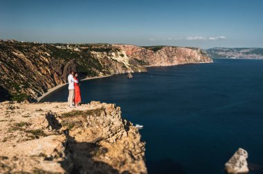 İki denizin kenarında batımında aşık. Balayı. Balayı gezisi. Erkek ve kız denizde. Erkek ve kadın seyahat. Çift sarılmalar. Çift öpüşme. Yeni evli çift. Seyahat düğün. Tatil Romantik