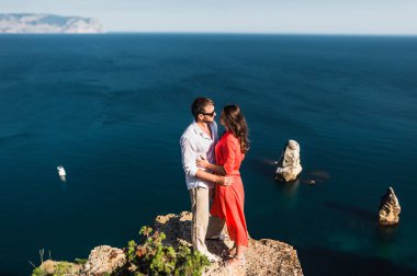 Gün batımında deniz kenarında aşık bir çift. Balayı. Balayı gezisi. Denizdeki kız ve erkek. Erkek ve kadın seyahat ediyor. Birkaç kucaklama. Çift öpüşmesi. Yeni evli bir çift. Sevgililer. Tatil aşkı