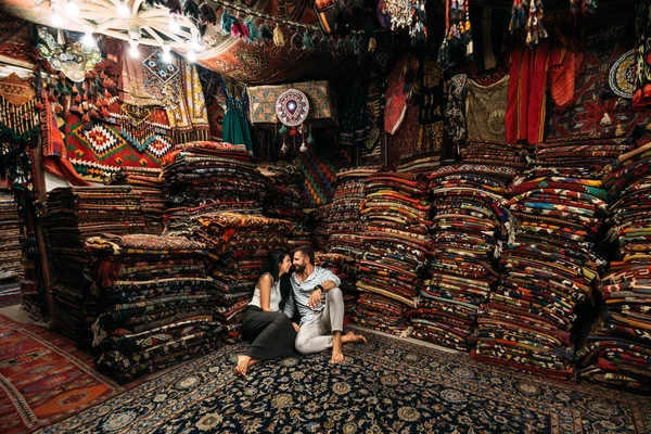 Couple having fun. Couple in love in Turkey. Man and woman in the Eastern country. Gift shop. A couple in love travels. Persian shop. Tourists in store. Oriental carpet. Cappadocia. Morocco