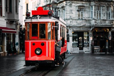 Istanbul'da Taksim Istiklal Caddesi'nde bir vintage tramvay kız. Toplu taşıma kız. Istiklal Caddesi, Türkiye'de eski Türk Tramvayda. Bir şehir sokak poz genç gülümseyen bir kadın portresi