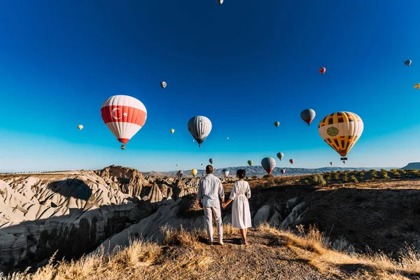 İki aşk arasında balonlar içinde. Sevgi dolu çift arka görüş. Kapadokya'da aşık çift. Türkiye'de kaç. Dağlarda balayı. Erkek ve kadın seyahat. Uçan balon üzerinde. Düğün. Yolculuk. Aşk