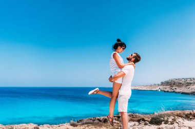 Denizin yanında mutlu bir çift. Denizde eğlenen kadın ve erkek. Balayı severler. Adadaki kadın ve erkek. Tatilde aşık bir çift. Deniz turu. Balayı gezisi. Mavi lagün aşık çift