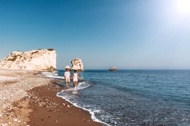 Kumlu sahilde el ele tutuşan mutlu çift. Gün batımında denizin yanında aşık olan bir çift. Tatilde aşık bir çift. Seyahat tatil konsepti. Romantik çift gün batımında bir plaj yürüyüşü zevk