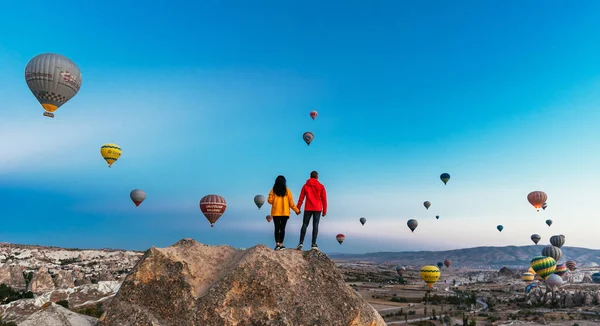 Balonlar arasında aşık olan bir çift. Kapadokya'da mutlu bir çift. Dağlarda balayı. Erkek ve kadın seyahat ediyor. Balonlarla uçmak. Balon Festivali
