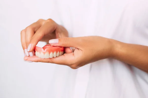 歯医者は彼の手に入れ歯を持っている 医師のクローズアップの手に歯科補綴 歯科概念写真 人工歯科 入れ歯 取り外し可能な入れ歯 — ストック写真