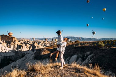 A couple in love in Cappadocia. The couple travels the world. Vacation in Turkey. Honeymoon in Cappadocia. Happy couple traveling. Honeymoon trip. Hot air balloon flights. Woman in the arms of a man