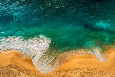 Deniz manzaralı bir yer. Deniz dalgalarının panoramik görüntüsü. Deniz kıyısında köpüklü dalgalar yuvarlanıyor. Deniz doğasının canlı bir resmi. Fırtınalı okyanus gelgiti. Endonezya plajları. Deniz köpüğü. Boşluğu kopyala