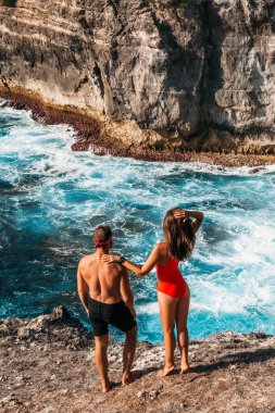 Sahildeki arka manzaralı bir çift. Balayı aşıkları. Adadaki kadın ve erkek. Tatilde aşık bir çift. Deniz turu. Balayı gezisi. Mavi Göl 'de aşık bir çift. Uzayı kopyala Dikey fotoğraf