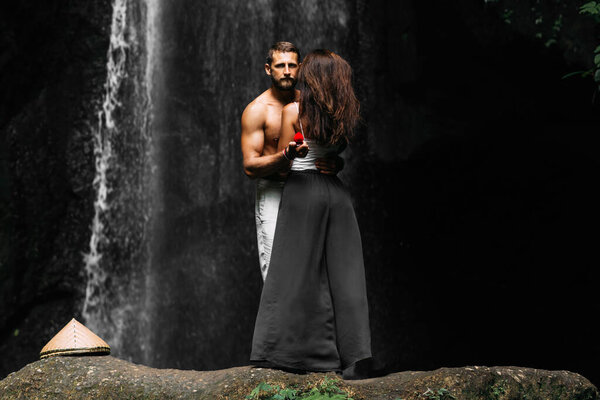 Предложение руки в путешествии. Поездка на медовый месяц. Мужчина делает предложение женщине у водопада. Парень делает предложение девушке на Бали. Признание в любви. Пара влюбленных на водопаде. Счастливая пара на Бали