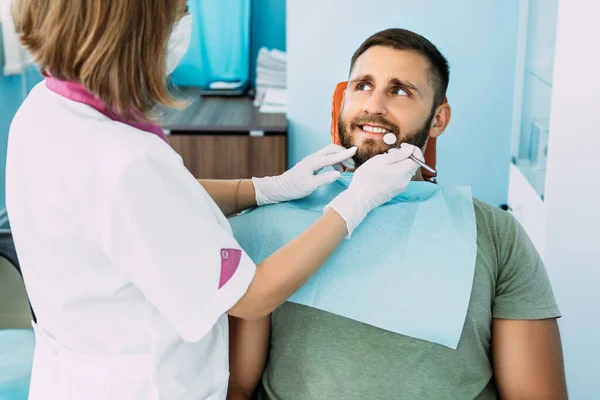 歯医者に歯を治療する男がいる 歯医者での歯科検査 歯の音 雪の白い笑顔 歯の検査を受けて美しい歯を持つ若い笑顔の男 歯科治療 — ストック写真