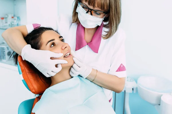 Dental examination of the patient. Dentist curing a woman patient in the dental office in a pleasant environment. Dentistry. Dental care. A woman treats her teeth at the dentist. Prevention of caries