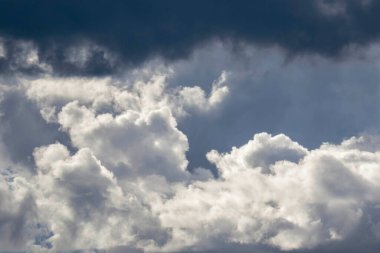 And 'ın gökyüzünde yükselen dramatik bulutların ayrıntıları, öğleden sonra ışıklarıyla zıt düşmek üzere olan fırtınalı bulut oluşumları..