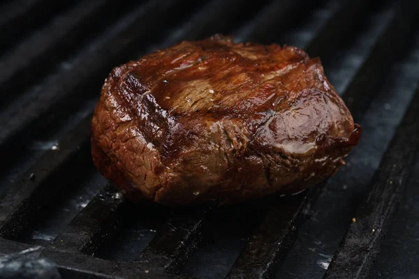 一大块肉 一份牛排 猪肉或小牛肉 躺在黑色的烤盘上 黑色的石板上 旁边的肉是香料和蔬菜 顶部视图 复制空间 — 图库照片#