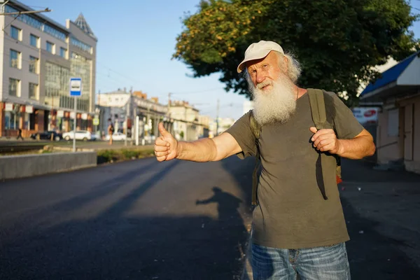 ひげ市内でタクシーを捕まえると幸せな老人 — ストック写真