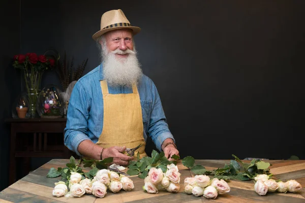 フラワー ショップの男性の花屋 エプロンの男は茎を切り バラの花束の準備です 小さなビジネスを行うフラワー ショップの所有者 — ストック写真