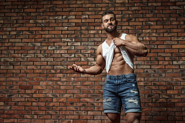 Portrait of strong healthy handsome Athletic Man Fitness Model posing near Brick wall — Stock Photo, Image