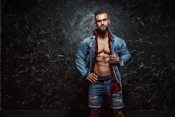 Portrait of strong healthy handsome Athletic Man Fitness Model posing near dark wall — Stock Photo, Image