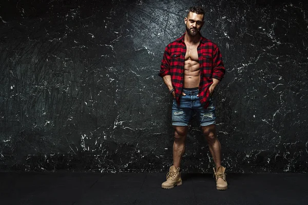 Portrait of strong healthy handsome Athletic Man Fitness Model posing near dark wall — Stock Photo, Image