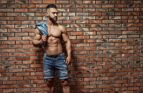 Portrait of strong healthy handsome Athletic Man Fitness Model posing near Brick wall — Stock Photo, Image