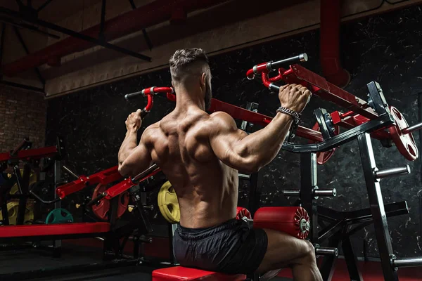 Jonge knappe sportman bodybuilder gewichtheffer met een ideaal lichaam, na coaching poseert voor de camera, buikspieren, biceps triceps. In sportkleding. — Stockfoto