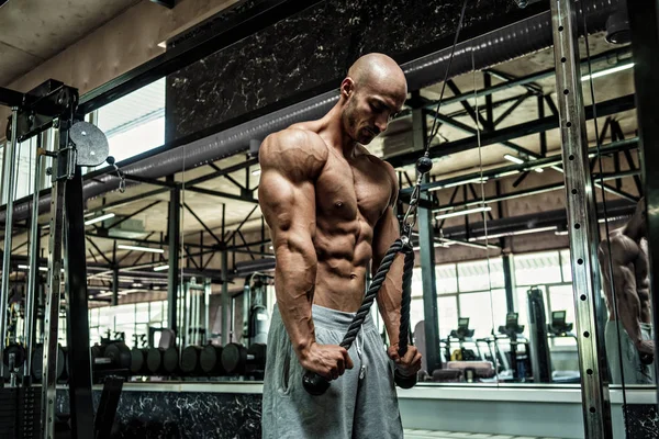 Jonge knappe sportman bodybuilder gewichtheffer met een ideaal lichaam, na coaching poseert voor de camera, buikspieren, biceps triceps. In sportkleding. — Stockfoto