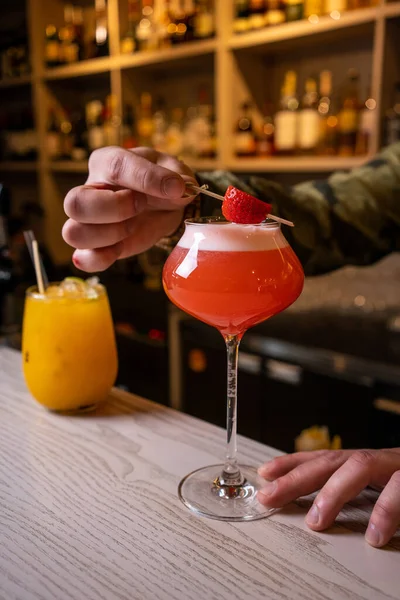 酒精饮料、人和奢侈的概念- -在酒吧里用杯子和柠檬皮调制鸡尾酒的酒保 — 图库照片