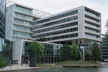 Bahçede cam cephe ve gölet ile modern ofis binası