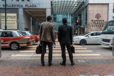 Hong Kong, Çin, Asya Harbor Plaza North Point Hotel önünde işlek sokakta iki erkek Arka görüş