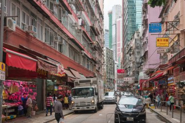 Çin, Hong Kong - 24 Nisan 2019: Balkon ve pencerelerle yüksek katlı konutların sokaklarında yürüyen insanların görünümü, Hong Kong Central