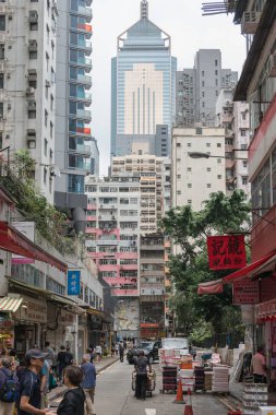 Çin, Hong Kong - 24 Nisan 2019: Balkon ve pencerelerle yüksek katlı konutların sokaklarında yürüyen insanların görünümü, Hong Kong Central