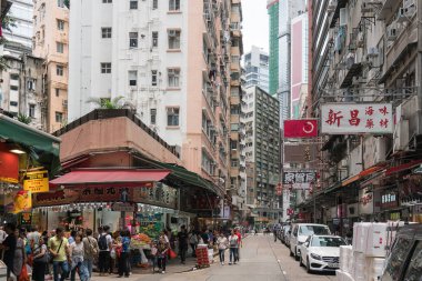 Çin, Hong Kong - 24 Nisan 2019: Balkon ve pencerelerle yüksek katlı konutların sokaklarında yürüyen insanların görünümü, Hong Kong Central