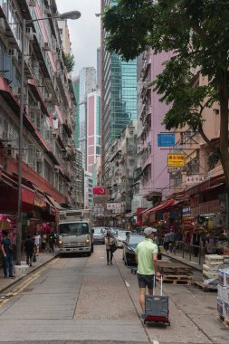 Çin, Hong Kong - 24 Nisan 2019: Balkon ve pencerelerle yüksek katlı konutların sokaklarında yürüyen insanların görünümü, Hong Kong Central