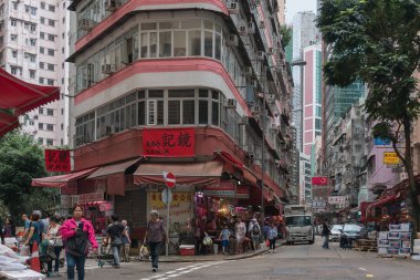Çin, Hong Kong - 24 Nisan 2019: Balkon ve pencerelerle yüksek katlı konutların sokaklarında yürüyen insanların görünümü, Hong Kong Central