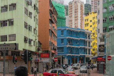 Çin, Hong Kong - 24 Nisan 2019: Balkon ve pencerelerle yüksek katlı konutların sokaklarında yürüyen insanların görünümü, Hong Kong Central
