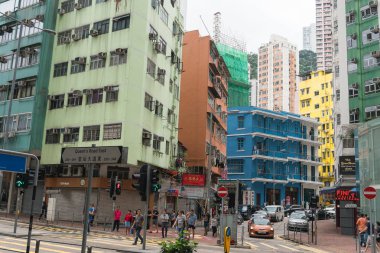 Çin, Hong Kong - 24 Nisan 2019: Balkon ve pencerelerle yüksek katlı konutların sokaklarında yürüyen insanların görünümü, Hong Kong Central