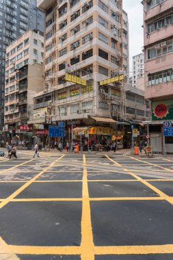 Çin, Hong Kong - 24 Nisan 2019: Balkon ve pencerelerle yüksek katlı konutların sokaklarında yürüyen insanların görünümü, Hong Kong Central