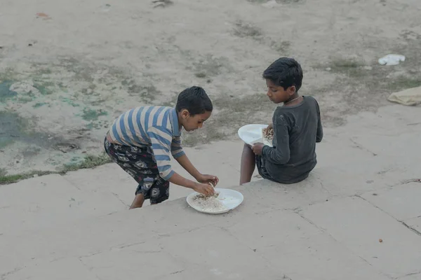 인도에서 축일에 거리에서 식사하는 소년들 스톡 이미지