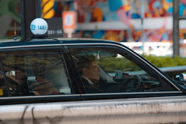 Bir arabanın içinde oturan sürücü.