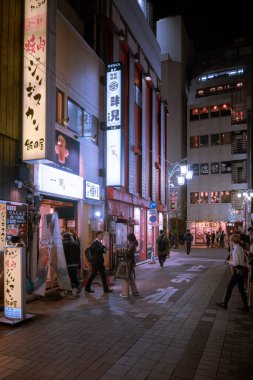 Gece vakti Çin caddesinde binaların ve insanların görüntüsü.