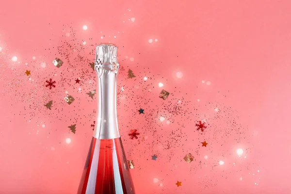 Julkoncept. Rosa champagne, glitter på rosa bakgrund Royaltyfria Stockbilder