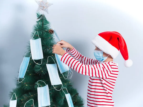 Gammel Gutt Dekorerer Juletre Med Operasjonsmasker Isolert Grå Bakgrunn – stockfoto