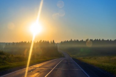 Sabah erken saatlerde yolda, ormanın etrafında, tarlalarda ve gündoğumunda.