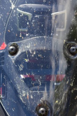 Motosikletin ön camında vidalar, bir sürü kirli ön cam.