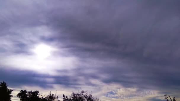 Время облачное небо с солнцем, сияющим сквозь облака и лучи света . — стоковое видео