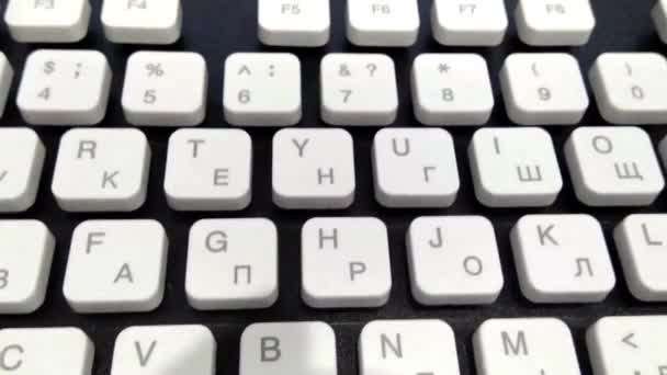 Bewegt sich die Kamera von oben über eine schöne, trendige Schwarz-Weiß-Tastatur. Nahaufnahme. Mehrsprachiges Tastaturlayout. — Stockvideo