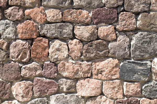 Colorful wall of volcanic stones closeup in sunny da