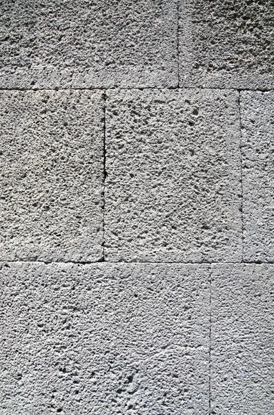 New wall of gray porous stone closeu